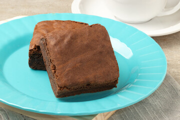 Delicious chocolate brownies on blue plate. Selective focus.