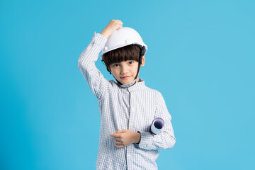 Asian boy portrait playing the role of an engineer, isolated on blue background