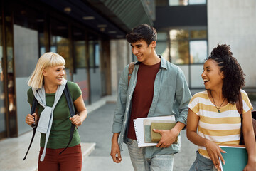 Group of happy college friends have fun while going on lecture at campus.