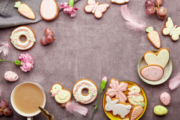 Obraz na płótnie Canvas Easter aesthetic coffee time background. Glazed decorated cookies, coffee cup, feathers flat lay. Spring stylish background with copy space.