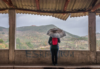 Solo female with umbrella walking in a small town on a rainy day