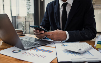 Fototapeta premium Businessman hands working on laptop computer with market report document and management business project, Business accounting concept.