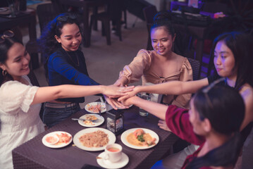 Work colleagues huddle in front of the table as they work together for a common goal. A-team showing unity in a healthy collaboration. Teamwork makes the dream work.