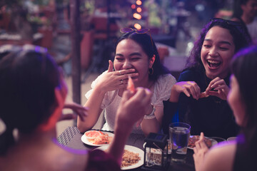 Chatty young women laugh and reminisce their high school life as they have a good time in a pub....