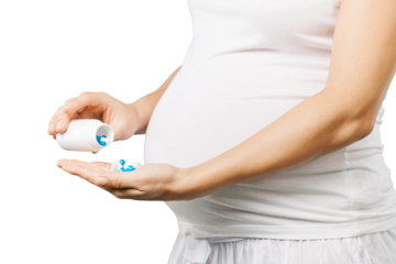 Pregnant woman holds medication pills