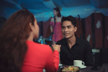An Asian guy shakes the woman's hand as they formally introduces each other on their first date. A...