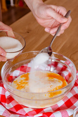 Cook. A man prepares pancake dough in a glass bowl.
