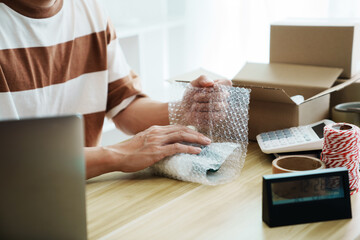 Small business owner packing in the cardbox preparing parcel for delivery online selling sell...