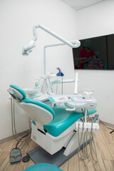 Empty dental office with one patient chair and oral treatment equipment.
