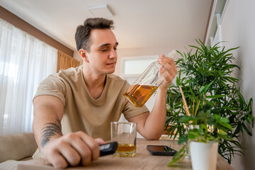 one man sit at home with bottle of liquor drink whiskey drunk alcoholic Alcohol abuse, addiction and man depression concept copy space