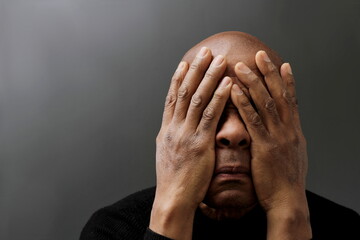 praying to god with hands together Caribbean man praying with black background stock photo