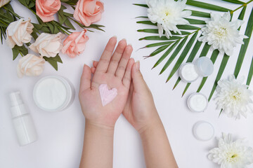 Moisturizing care skincare face cream for healing complicated troubled skin type. girl smears her hands cosmetic cream. skin care, elastic and young skin of the hands. flat lay, top view.