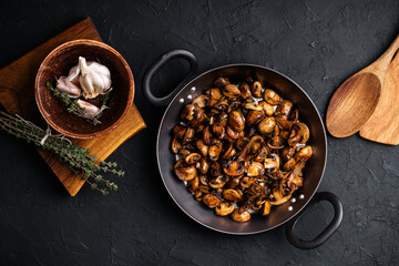 Sauteed mushrooms with onion and thyme in frying pan, vegan meal