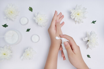 Moisturizing care skincare face cream for healing complicated troubled skin type. girl smears her hands cosmetic cream. skin care, elastic and young skin of the hands. flat lay, top view.