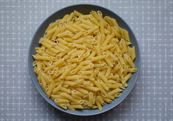 Pasta in a bowl. Uncooked pasta, flat lay.