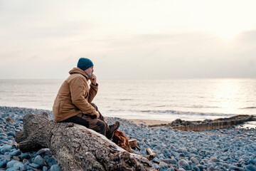 Bearded Man relaxing alone on the seaside on cold winter day. Travel  Lifestyle concept