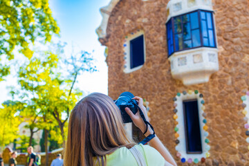 Young woman tourist takes a picture in the famous Guell park in Barcelona. 