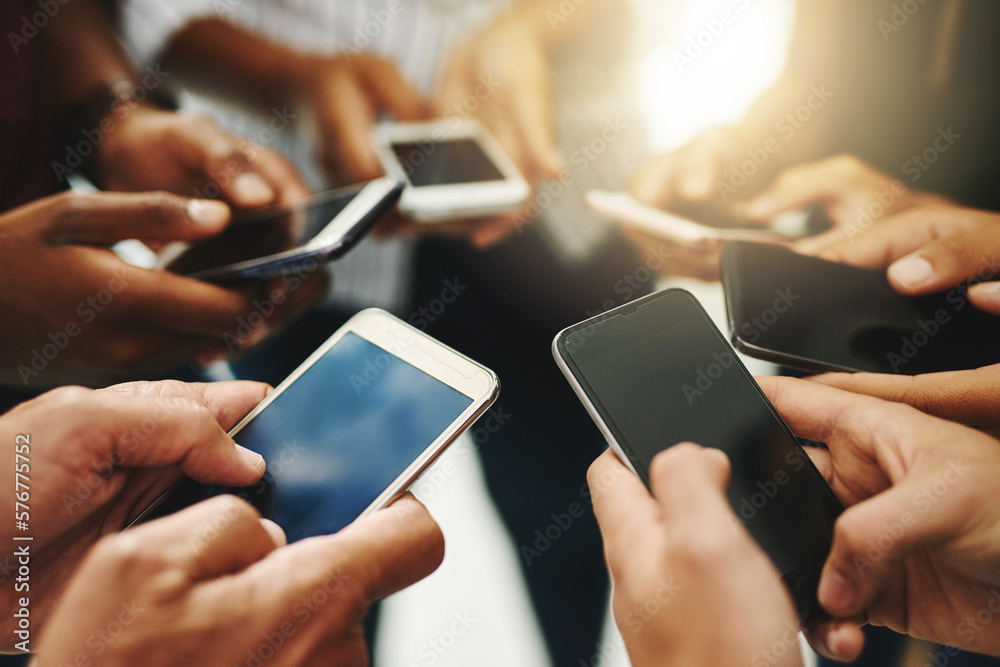 Aufkleber were all connected. closeup shot of a group of unrecognizable businesspeople using their cellphones 
