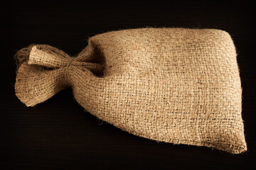 Empty burlap or burlap sack isolated on dark background. Front view, design element. Close-up