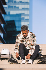 Latino ethnic man preparing to skate in the city park