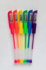 Colorful gel neon rainbow colors pens on white background