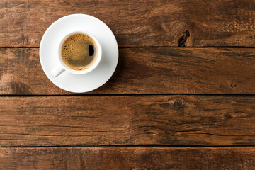 Coffee cup on vintage wooden table with copyspace. Top view