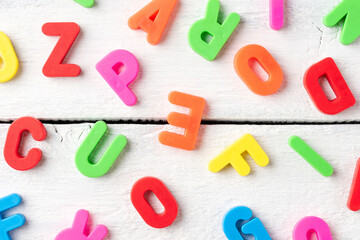 Obraz premium Colourful letters on white wooden background - pattern. School background