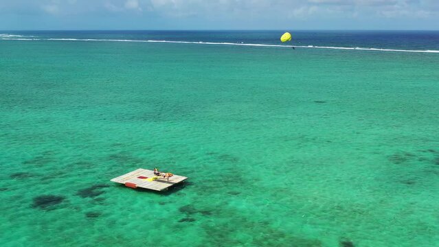 Aerial view of a person doing paraflying Grand Baie harbour, northern Mauritius.