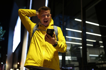 Happy excited man looking at smartphone screen with happiness
