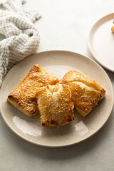 Puff pastry dough. Folded baked puff pastry pies in a plate.