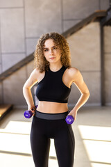 Fototapeta na wymiar Sporty woman exercising with dumbbell at home to stay fit