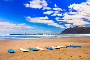 Poster Surfboards on wide sandy beach Famara - famous beach for surfing in Lanzarote, Canary islands © Freesurf