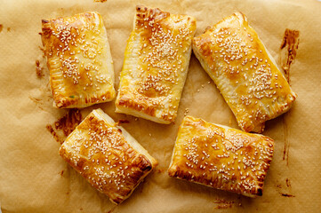 Puff pastry dough. Folded baked puff pastry pies portions, top view.