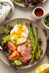 Healthy breakfast - asparagus wrapped with bacon, benedict poached egg and salad. 