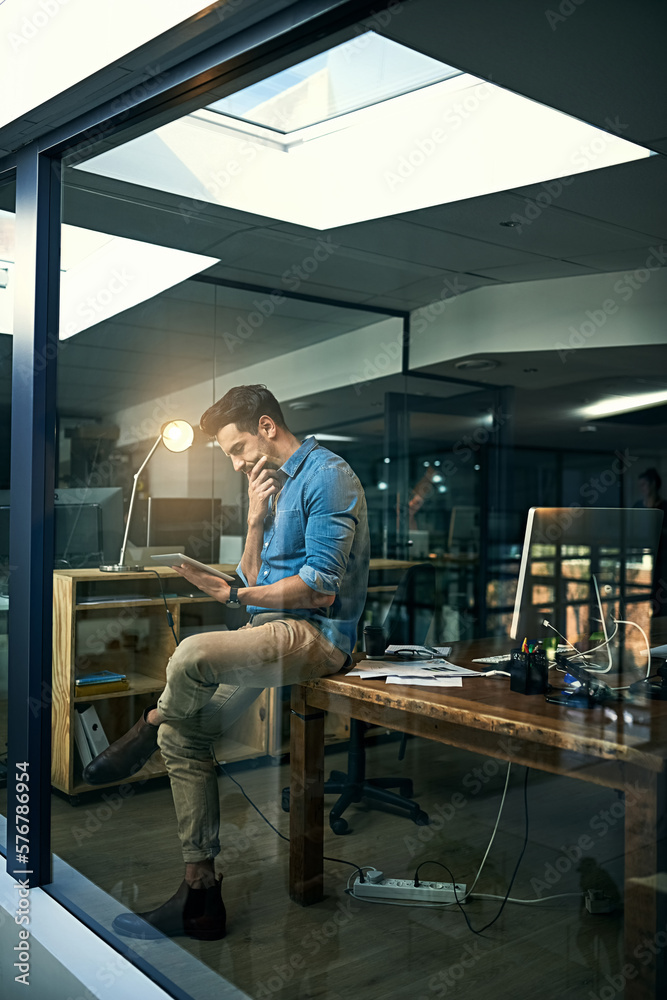 Poster his motto - its not done until its done. shot of a young businessman using a digital tablet during a