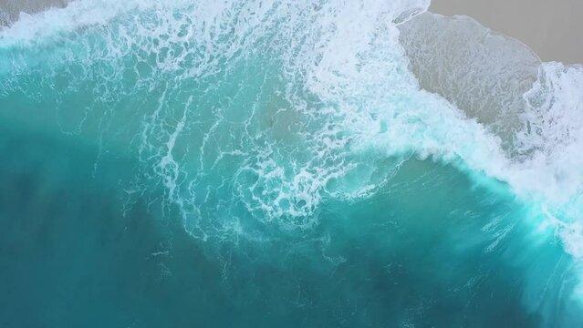 Aerial view of waves rolling on the shoreline along the coast on Maldives Islands.