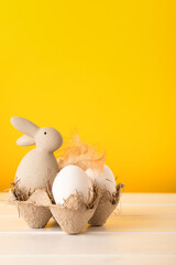 easter bunny and eggs on a yellow background, front view, copy space, easter concept
