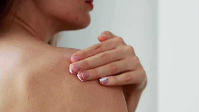 Unrecognizable Young Caucasian Woman Applying Moisturizing Cream On Her Bare Shoulder, Doing Bodycare Procedures After Shower. Beauty And Healthy Skin Care Treatment. Female Body Pampering Concept