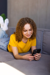 Portrait beautiful young woman use smart phone on sofa in living room interior