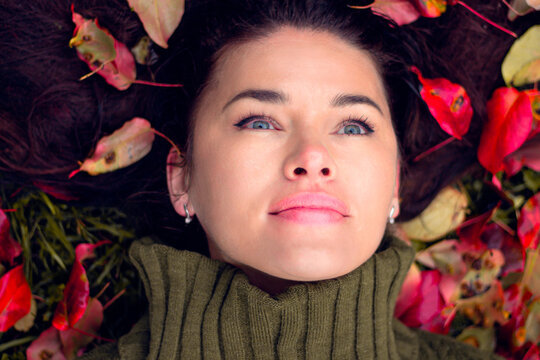Portrait of a woman lying in colorful autumn leaves