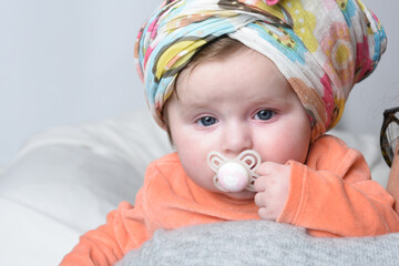 portrait of a baby with a head scarf