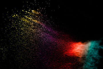 Fototapeta na wymiar Explosion of colorful Holi powder on black background. Vibrant color dust particles textured background.