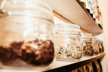 different glass jars with marshmallows and chocolate on a shelf in a cafe 