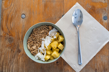 Top view of typical brazilian açaí bowl with cereals, coconut and pineapple. Healthy breakfast.