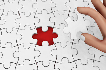 A hand holding a piece of jigsaw going to complete a puzzle. Illustration of the concept of achievement and completion and as a copy space
