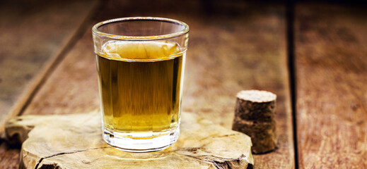 cachaça, brazilian drink with sugar, lemon and ice, typical distilled drink from brazil, on wooden bar background