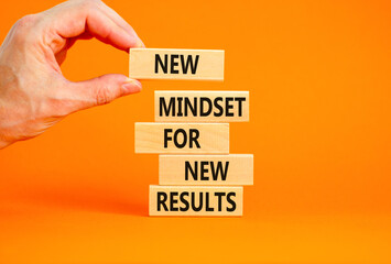 New mindset and results symbol. Concept words New mindset for new results on wooden blocks. Beautiful orange background. Businessman hand. Business new mindset for results concept. Copy space