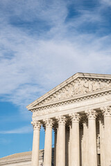Obraz premium Imposing facade of the United States Suprement Court in Washington, DC with blue sky and copy space.