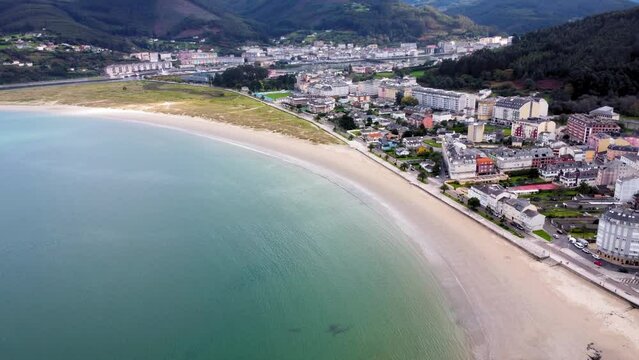 Aerial perspective of beautiful landscaped of Galicia. View of Covas city, at left is Viveiro city. Villages at the base of the mountain. Typically Galician landscape. Drone ascending panning right