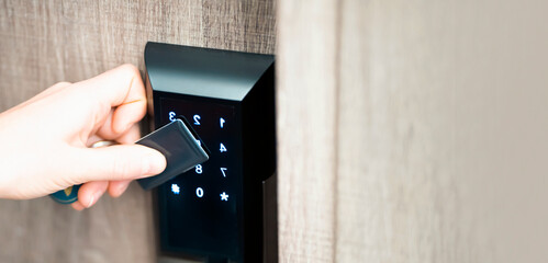 A girl is opening a door with a smart card - key, a modern lock.